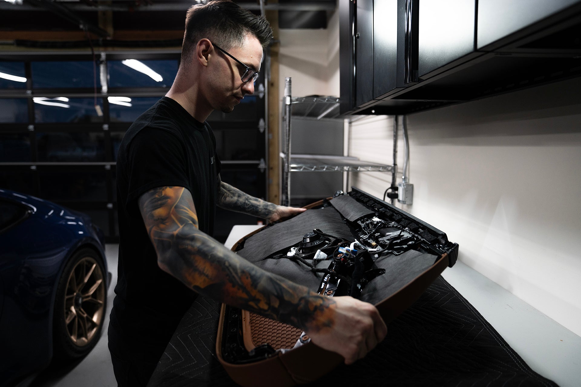 Nick Apicella of ResoNix holding car door panel that has ResoNix CLD Squares sound deadening material and Fiber Mat sound absorber installed onto it