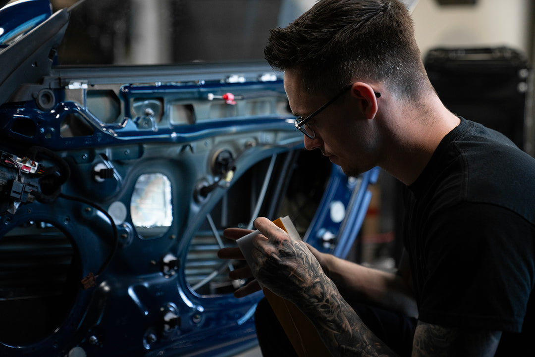 Nick Apicella installing ResoNix Lockout automotive and marine sound absorption material into the door of a Porsche 911 GT3 Touring