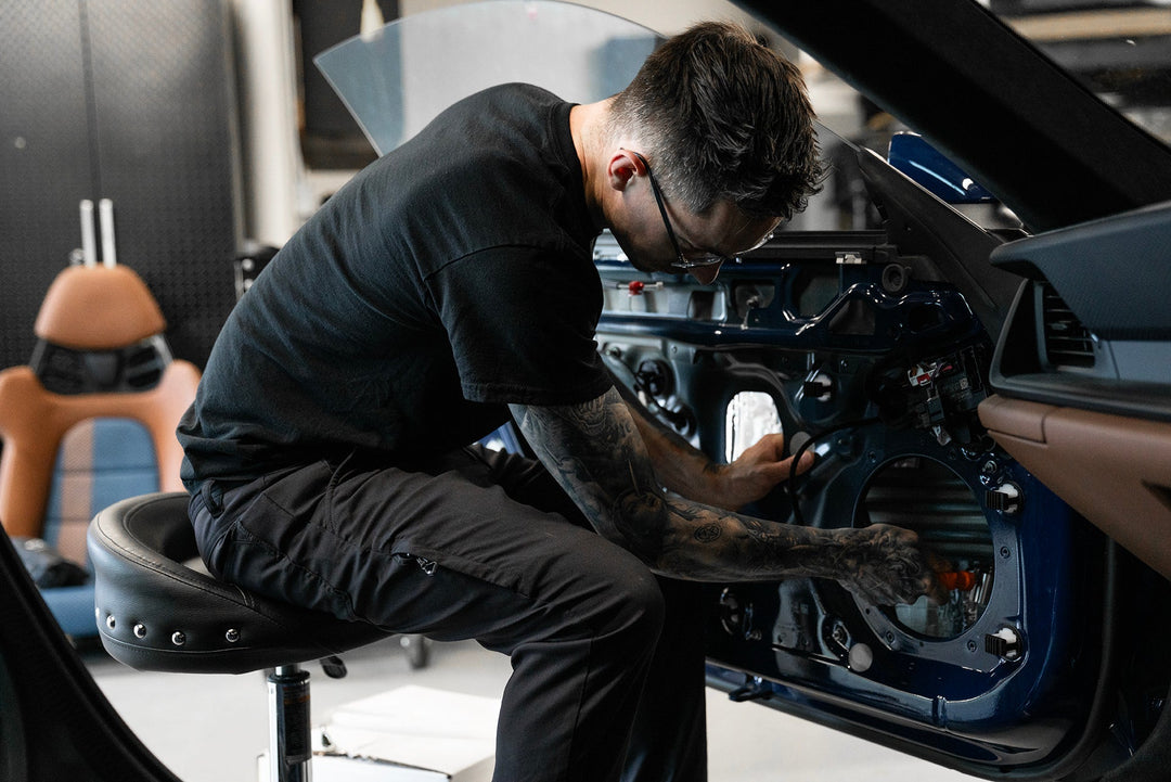 someone installing automotive sound deadener into a porsche 911 door