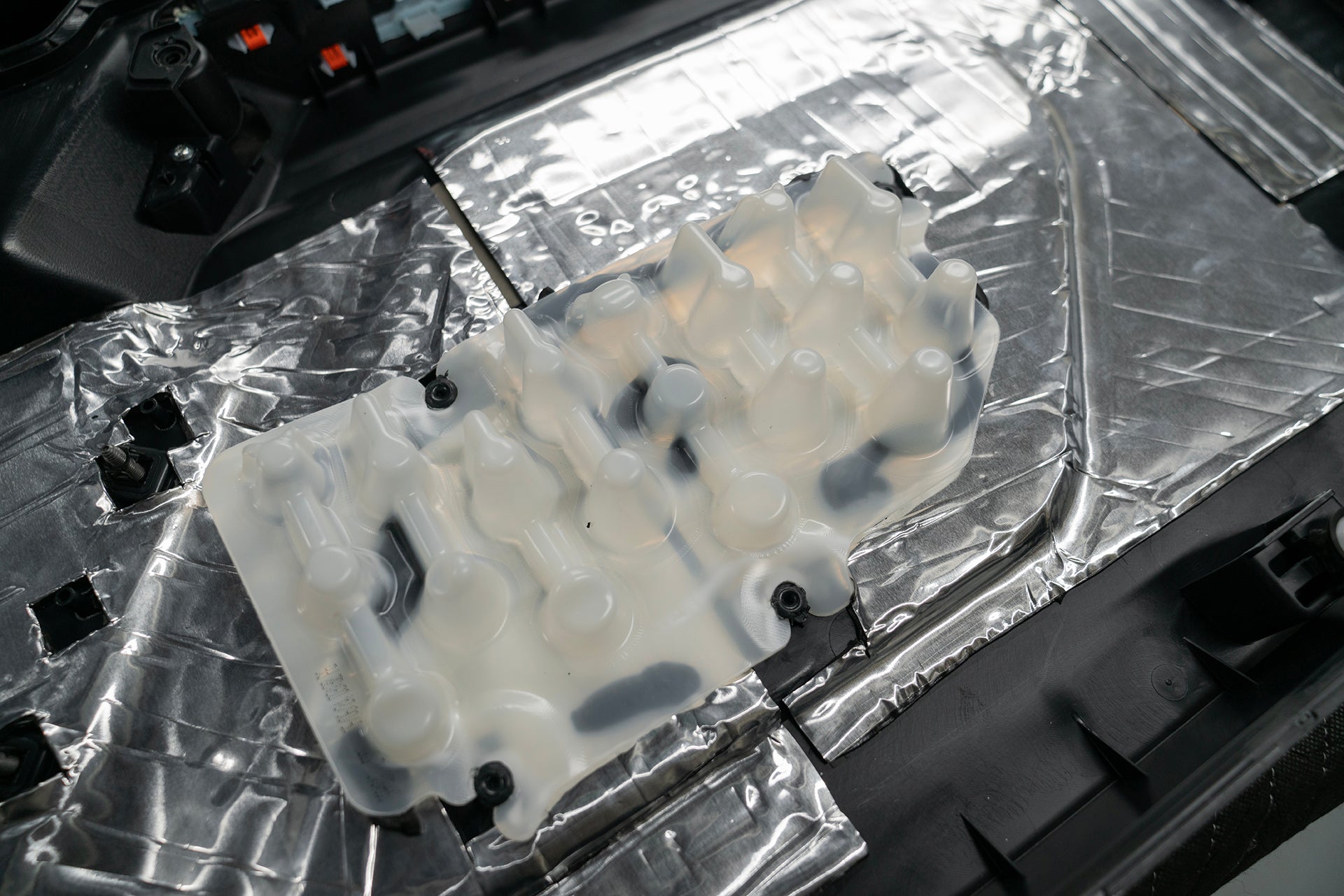 Back of Ford Bronco door panel with ResoNix CLD Squares applied and close up of insert