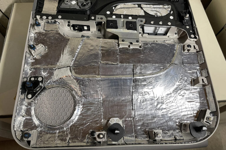 rear of a car door panel covered with ResoNix CLD Squares sound deadening material to reduce resonance