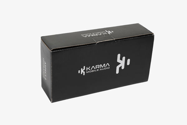 A pair of Karma Mobile Audio Aspect 3 three inch midrange speakers with black grilles inside of their closed shipping box