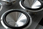 Close-up of speaker cones of the Micro precision Z-Studio 6.5" midbass speakers on a gray surface.