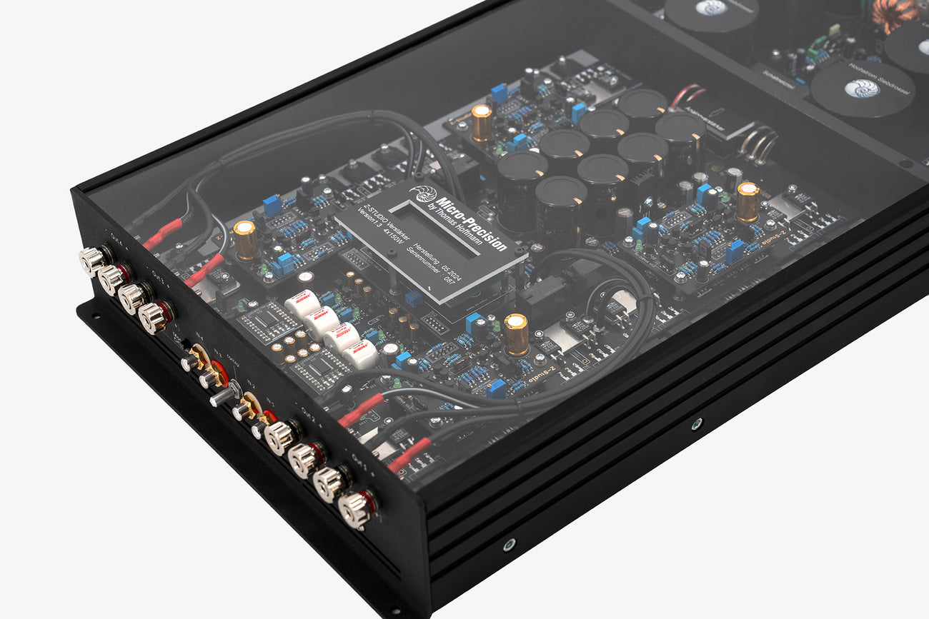 The input and output end panel of the Micro Precision Z-Studio 4c 4-channel car audio amplifier with visible electronic components, circuitry, and connectors on the top surface.