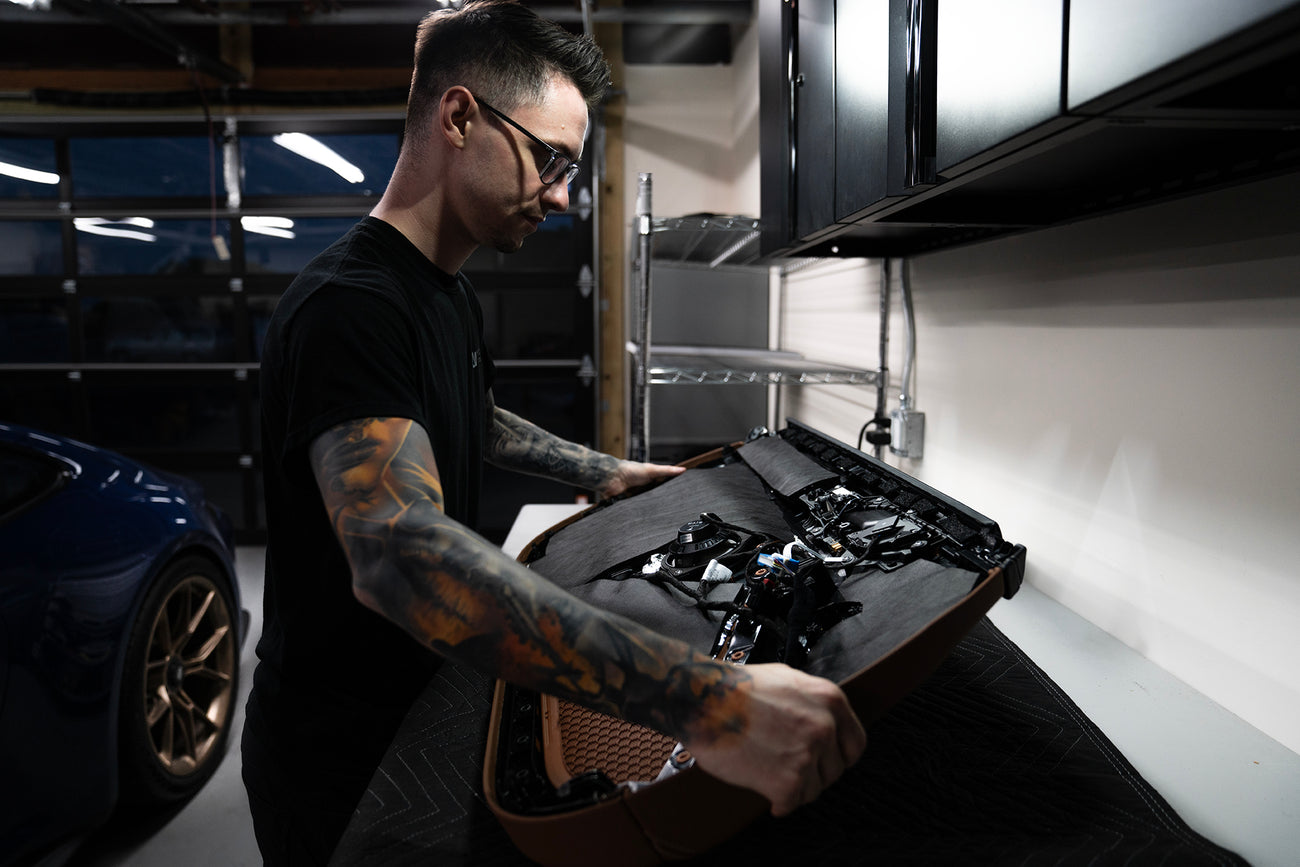 Nick Apicella of ResoNix Sound Solutions inspecting the installation of ResoNix Fiber Mat on the back of a car door panel