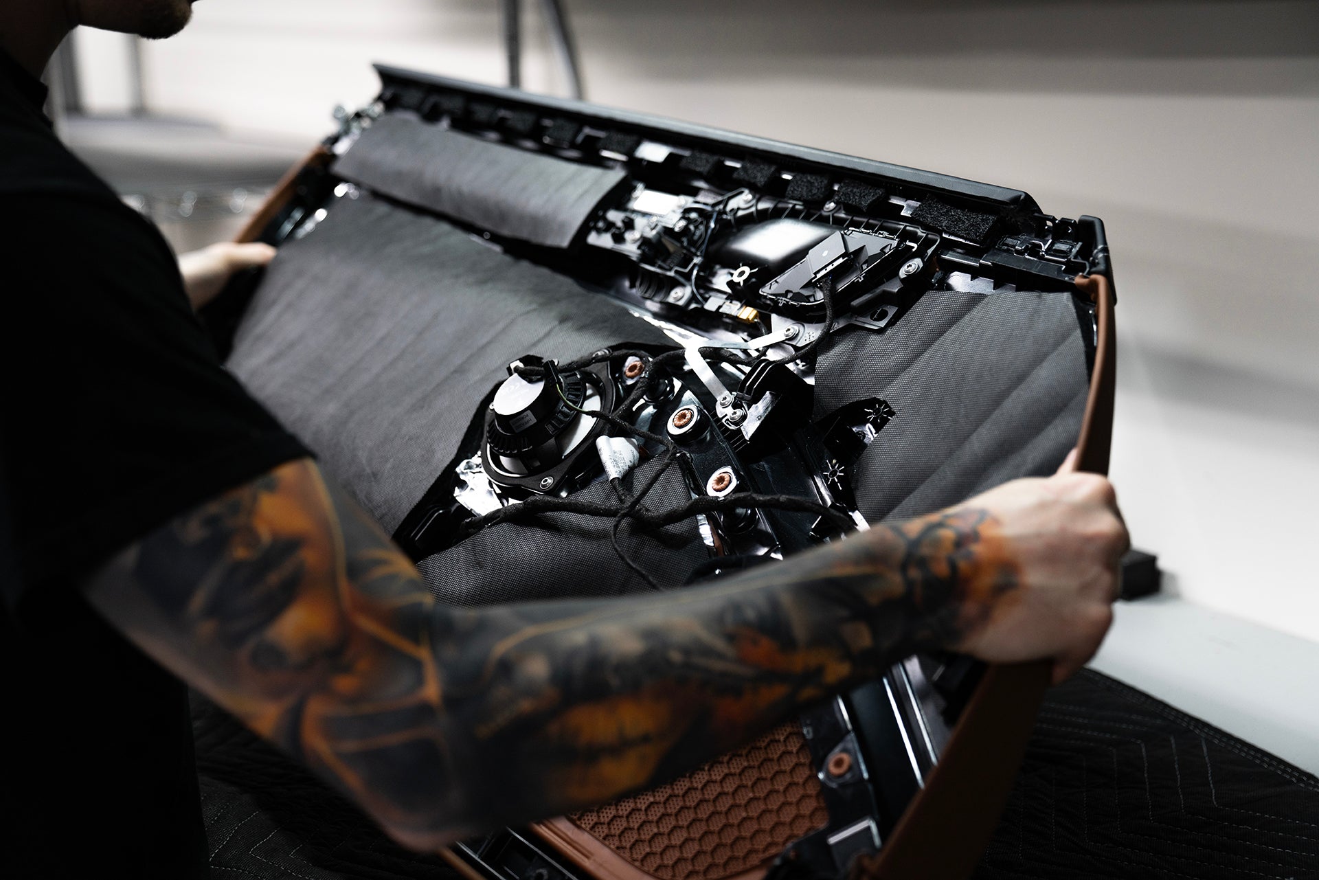 ResoNix Fiber Mat automotive sound insulation material installed onto the back of a car door panel being held by Nick Apicella of ResoNix