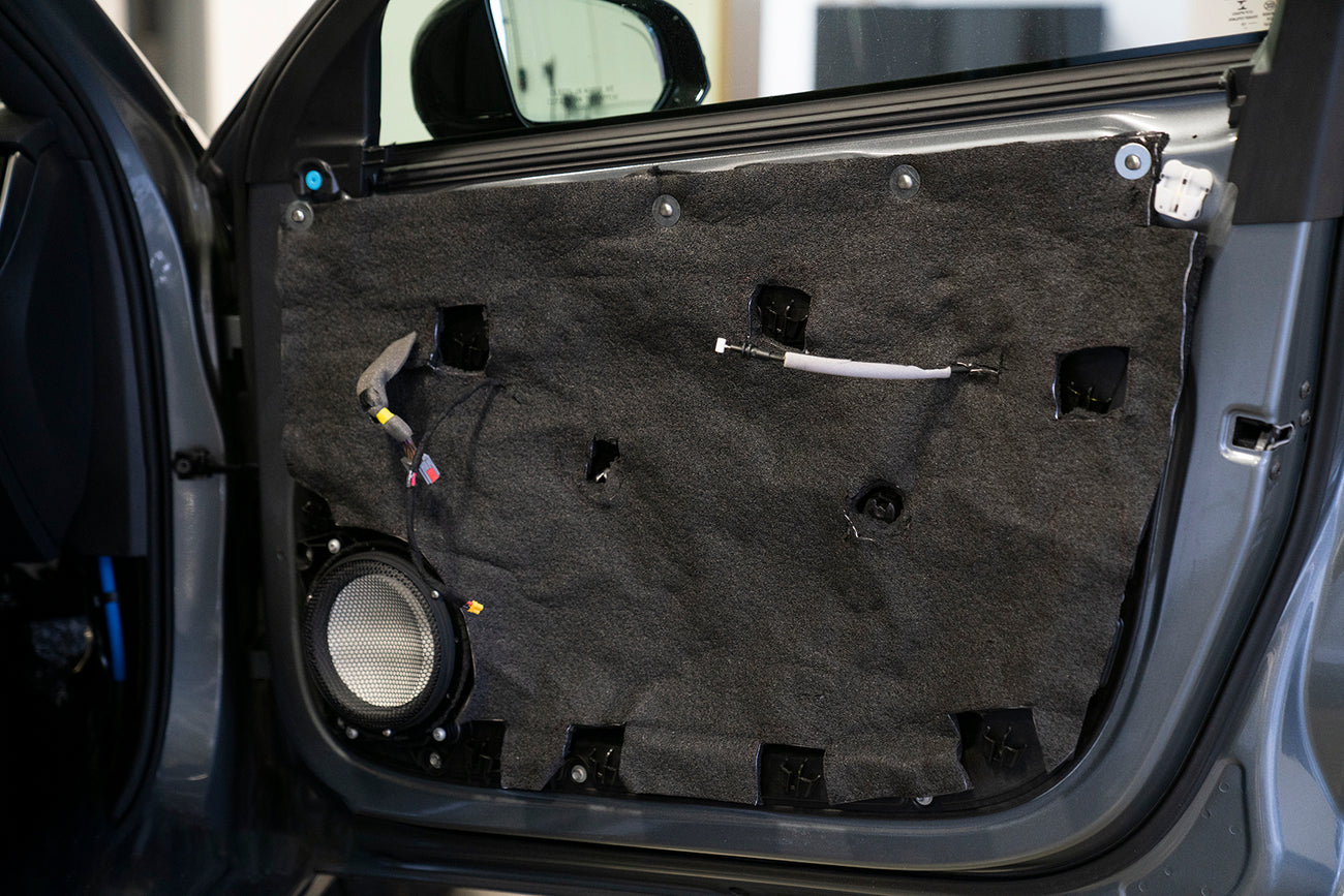 car door with door panel removed showing the inner door skin that is treated with ResoNix Barrier mlv replacement material and an Accuton Automotive C165AM 6.5" midbass speaker installed
